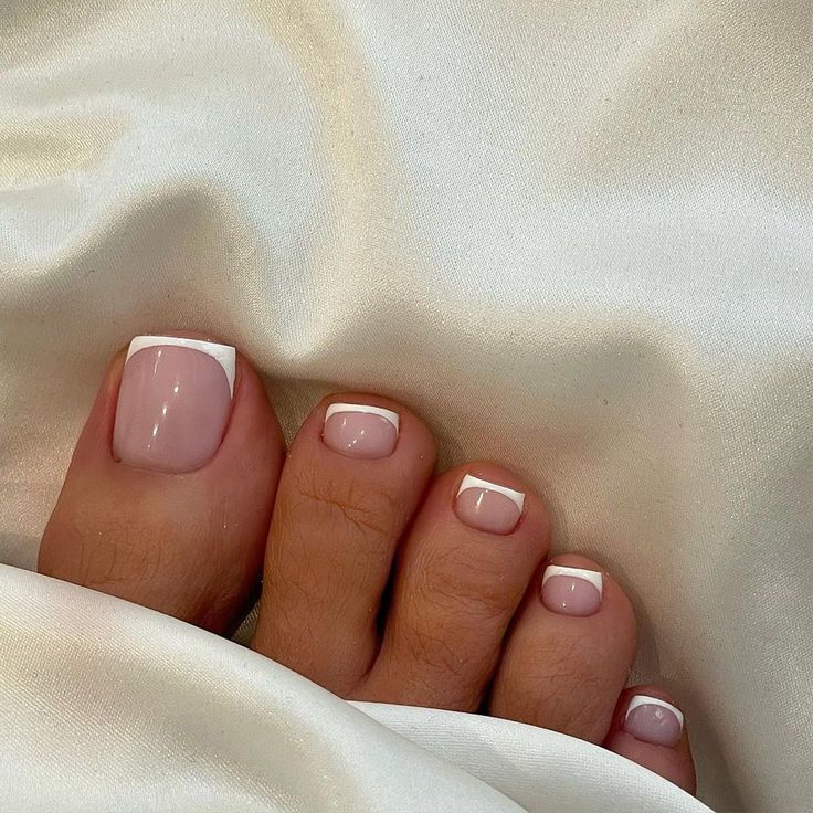 Sophisticated French Tip Pedicure: Soft Pink Base with Classic White Tips for Versatile Elegance.