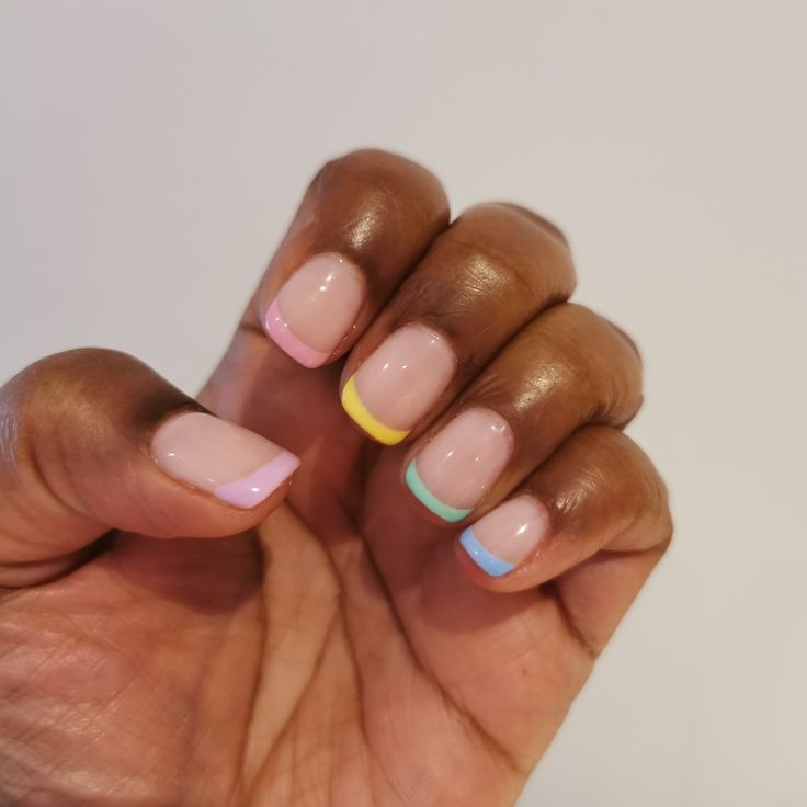 Playful Pastel Nail Design with Nude Base and Vibrant Tips for an Elegant Look.