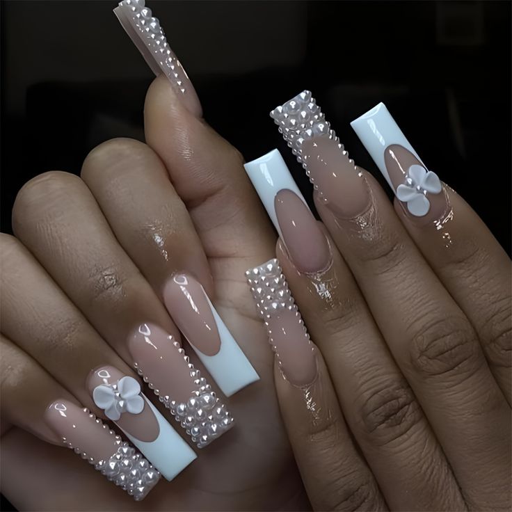 Luxurious Nude and White Nail Design with Pearls and Floral Accents.