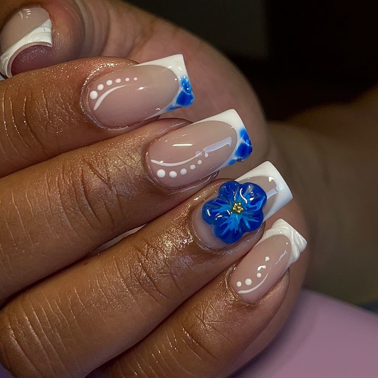 Sophisticated French Tip Nail Design with Floral Accents and Whimsical Pearls.