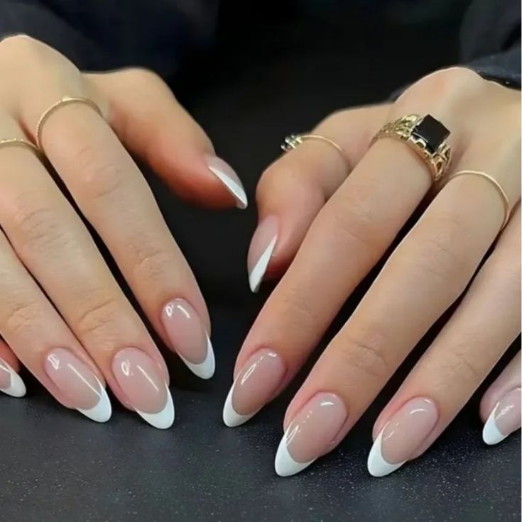 Sophisticated Almond-Shaped French Tip Manicure with Natural Nude Base and Delicate Accents.