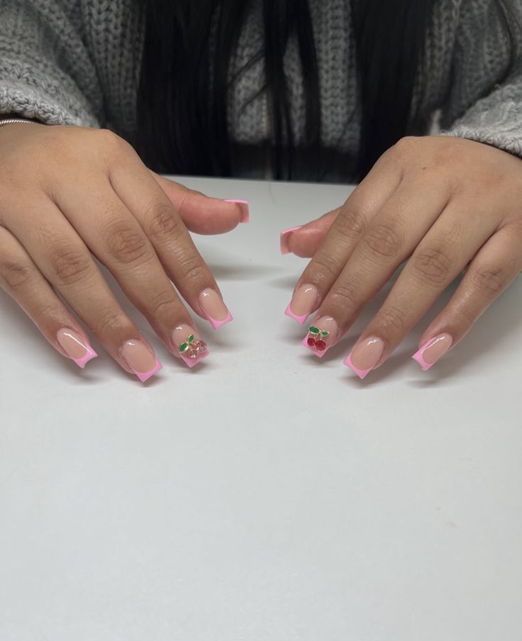 Elegant Soft Pink French Tip Nails with Whimsical Floral Embellishments for a Playful, Trendy Look.