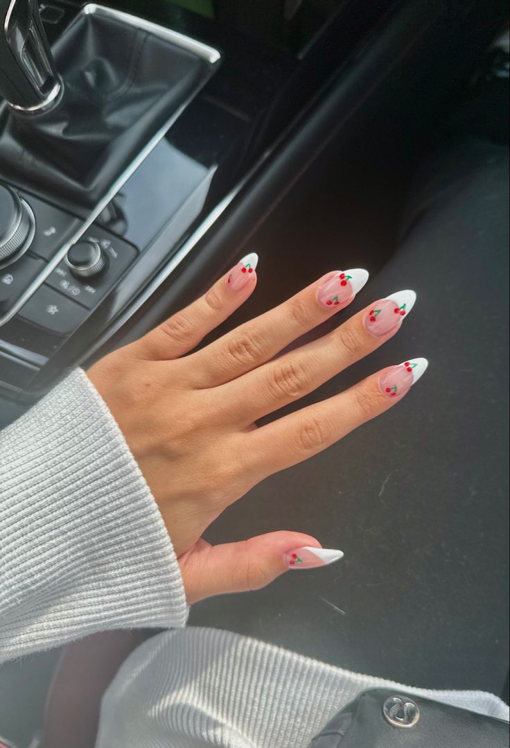 Chic White Base Nail Design with Delicate Pink Floral Accents and Pointed Tips.