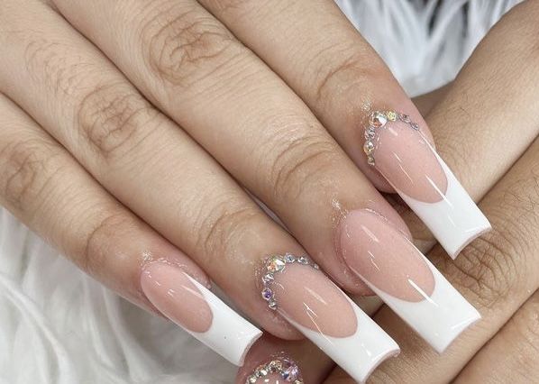 Chic Nude and White Nail Design with Rhinestone Accents for Elegant Occasions.