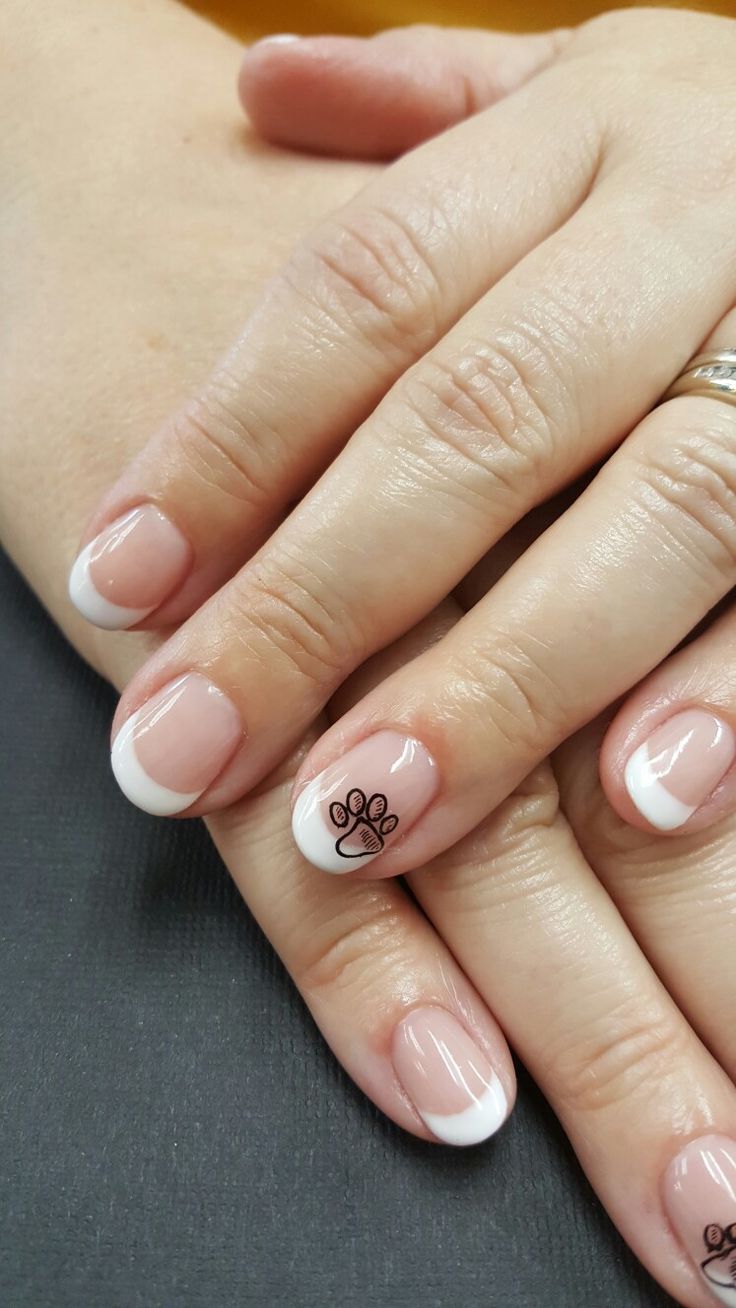 Chic French Manicure with Playful Paw Print Accent for Animal Lovers.