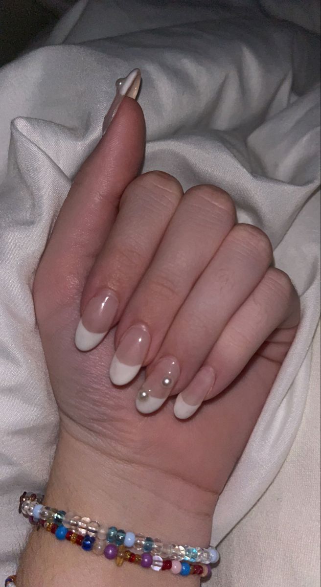 Elegant French Tip Nail Design with Glossy Finish and Pearl Accents.