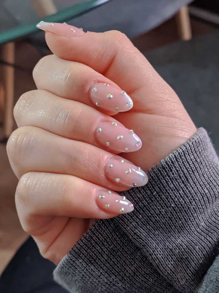 Chic and Sophisticated Translucent Nail Design with Sparkling Embellishments.