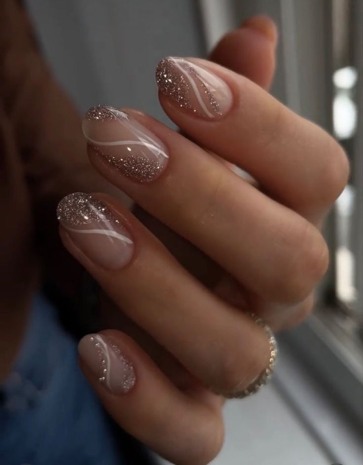 Sophisticated Elegant Nail Design: Soft Nude Base with Glitter Accents and Delicate White Swirls