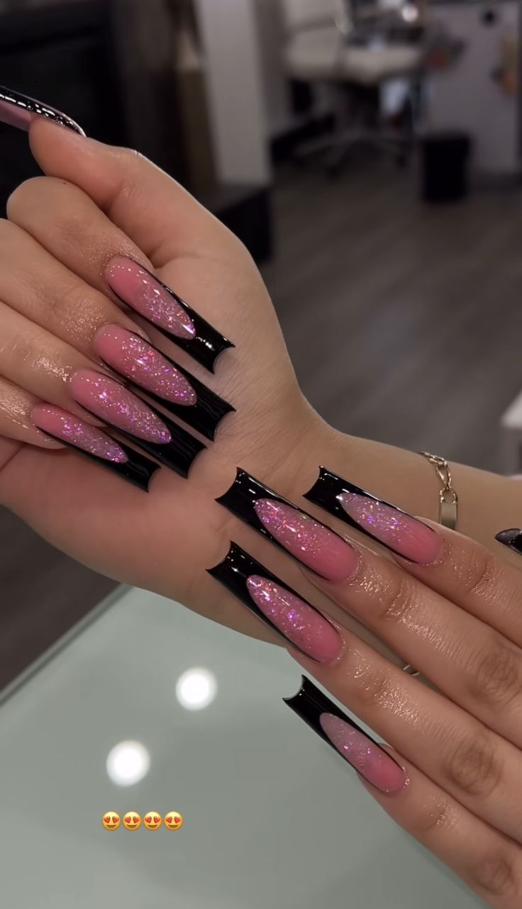 Sophisticated Glossy Pink Nail Design with Striking Black Tips and Shimmering Accents.