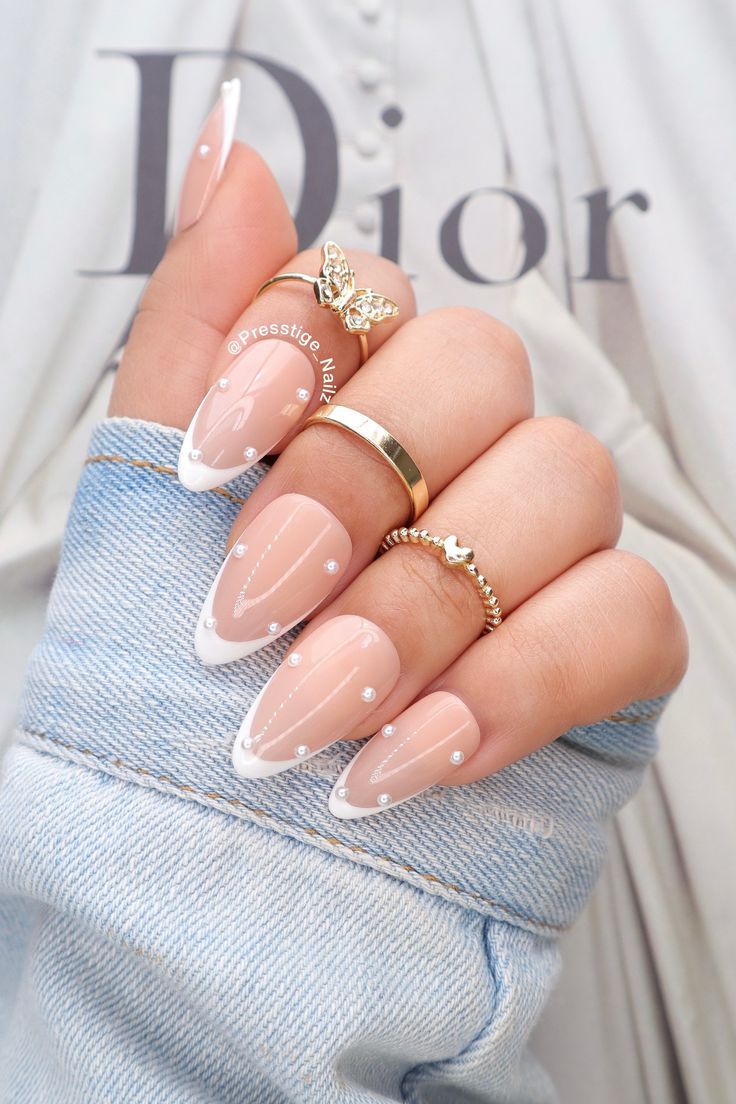 Sophisticated Nude and White French Tip Nail Design Adorned with Pearls and Drops.