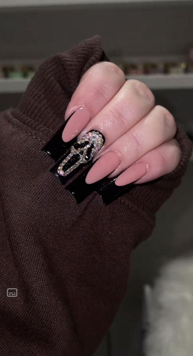 Chic Matte Nude Nail Design with Black and Rhinestone Accents for Modern Glamour.