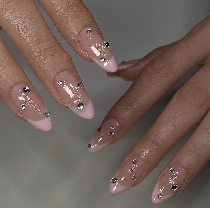 Sophisticated Soft Pink Ombre Nail Design with Metallic Embellishments and Glossy Finish.