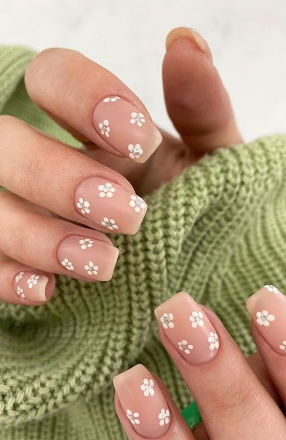 Elegant Floral Nail Design with Nude and Transparent Elements.