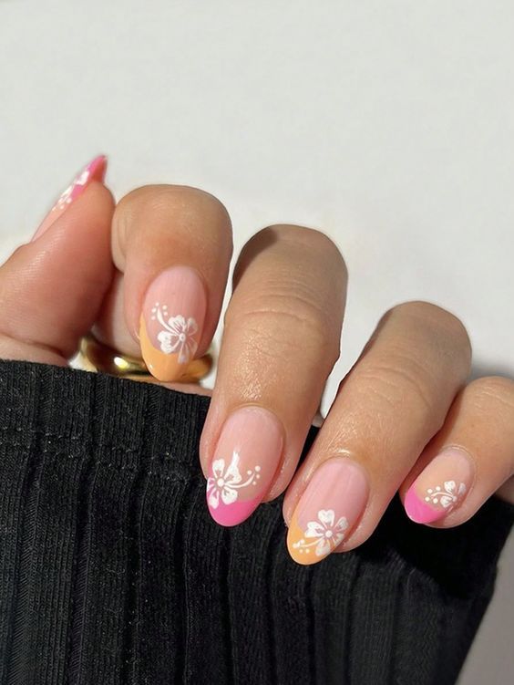 Spring-Inspired Floral Nail Design: Delicate White Flowers on a Soft Pink and Orange Gradient with Vibrant Pink Tips.