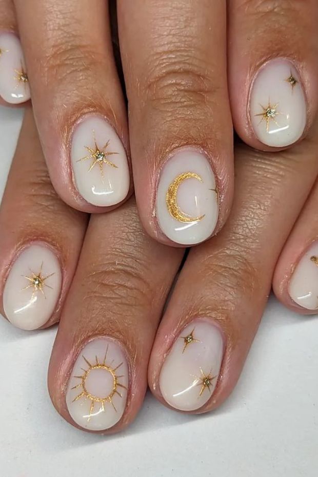 Cosmic Elegance: Celestial Nude Nail Design with Gold Accents.