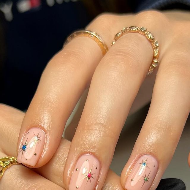 Whimsical Star-Motif Nail Design with Soft Nude Base and Vibrant Colors