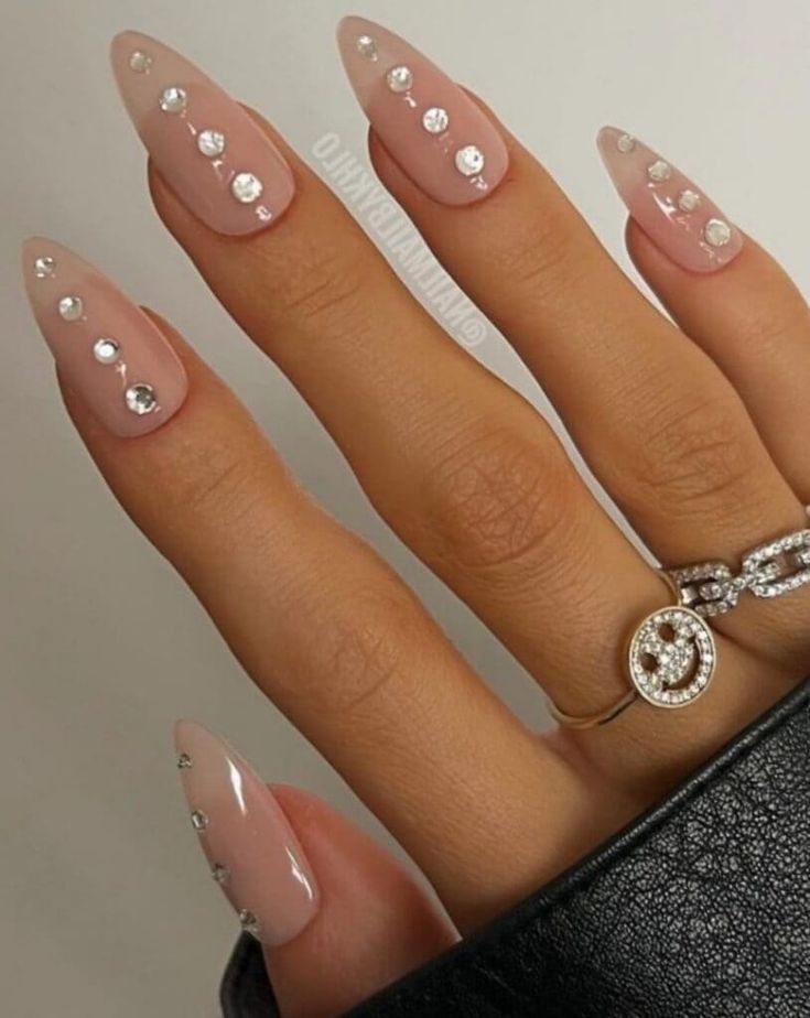 Chic Stiletto Nails with Nude Base and Rhinestones for Glamorous Elegance.