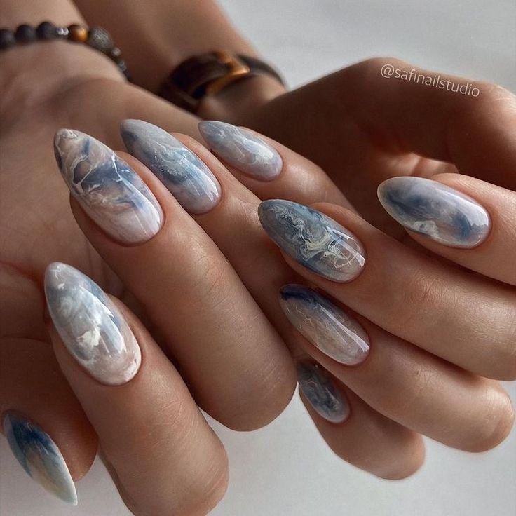 Elegant Marble Nail Design with Soft White and Dreamy Blue Hues.