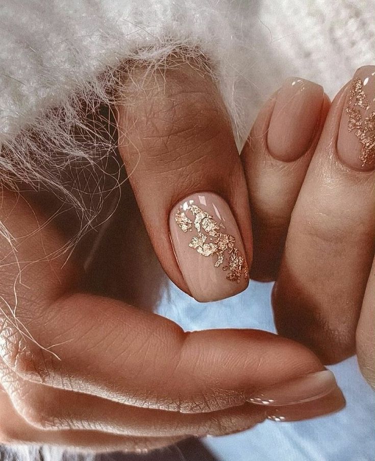 Sophisticated Nude Nail Design with Delicate Gold Leaf Accents.