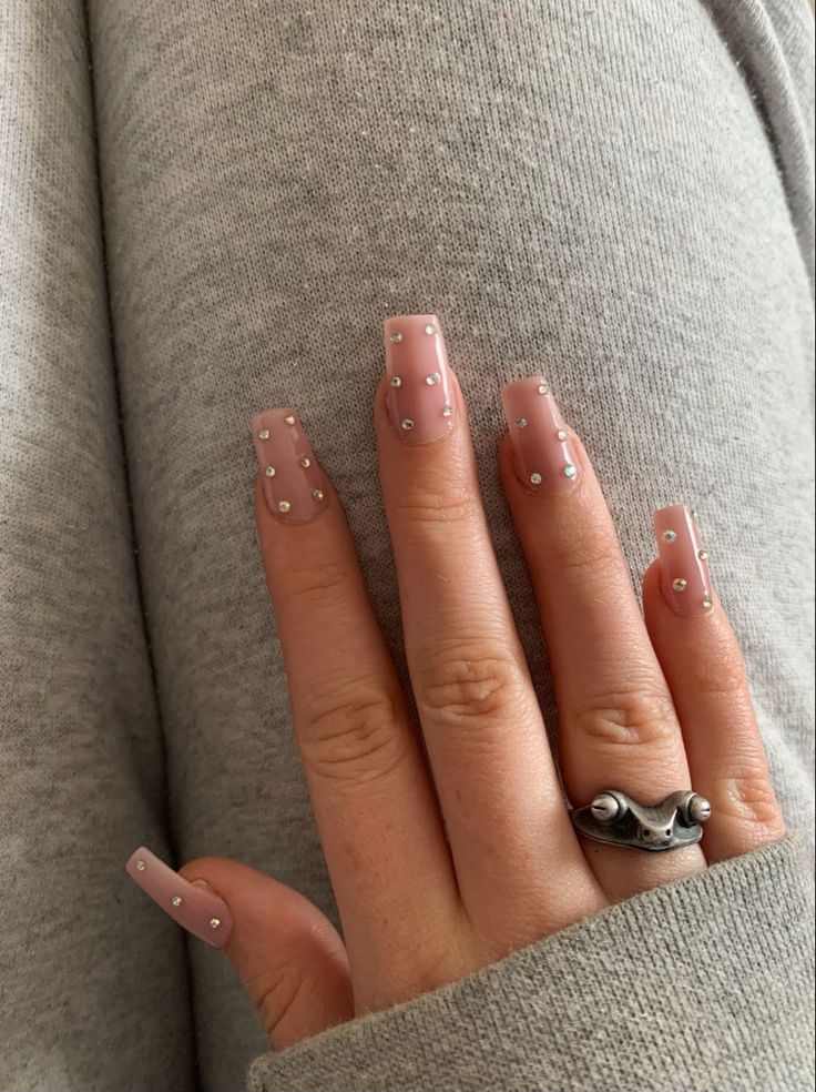 Sophisticated Soft Pink Nail Design with Delicate Rhinestones for Glamorous Looks.