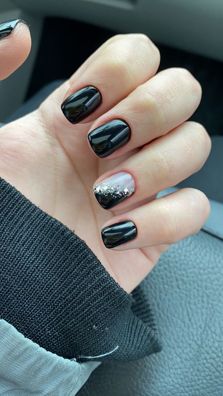 Chic Black Nail Design with Sparkling Silver Glitter Accent.