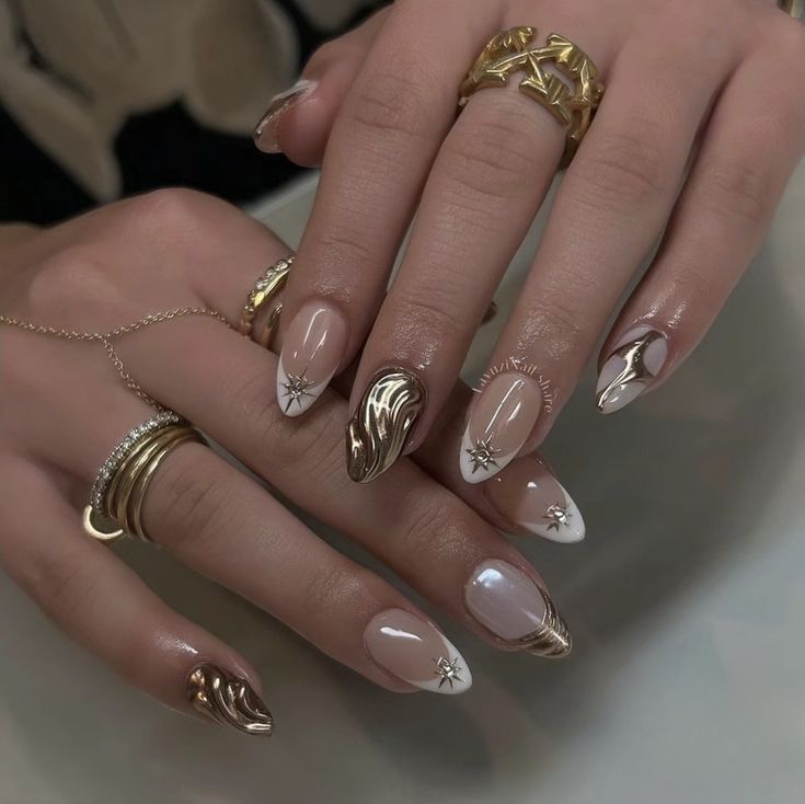 Sophisticated Nail Design with Neutral and Gold Tones, Intricate Patterns, and Star Embellishments.