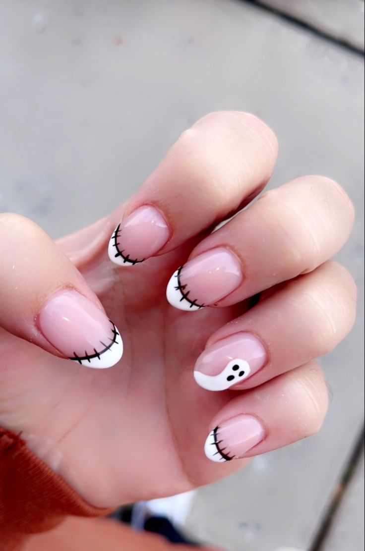 Whimsical Halloween Nail Design: Soft Pink and White with Charming Stitching and Ghost Accent.