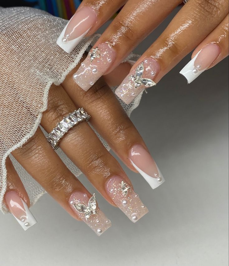 Whimsical Sophistication: Elegant French Tip Nail Design with Intricate Art and Embellishments.