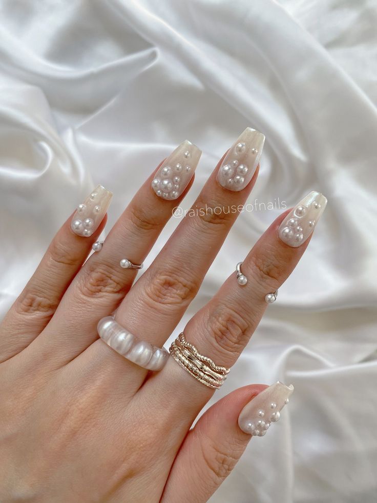 Elegant Nude Pearl Nail Design with Glossy Accents for a Chic Aesthetic.