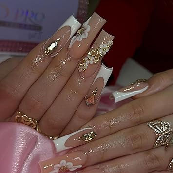 Luxurious Nude and White Nail Art with Floral Patterns and Sparkling Accents.