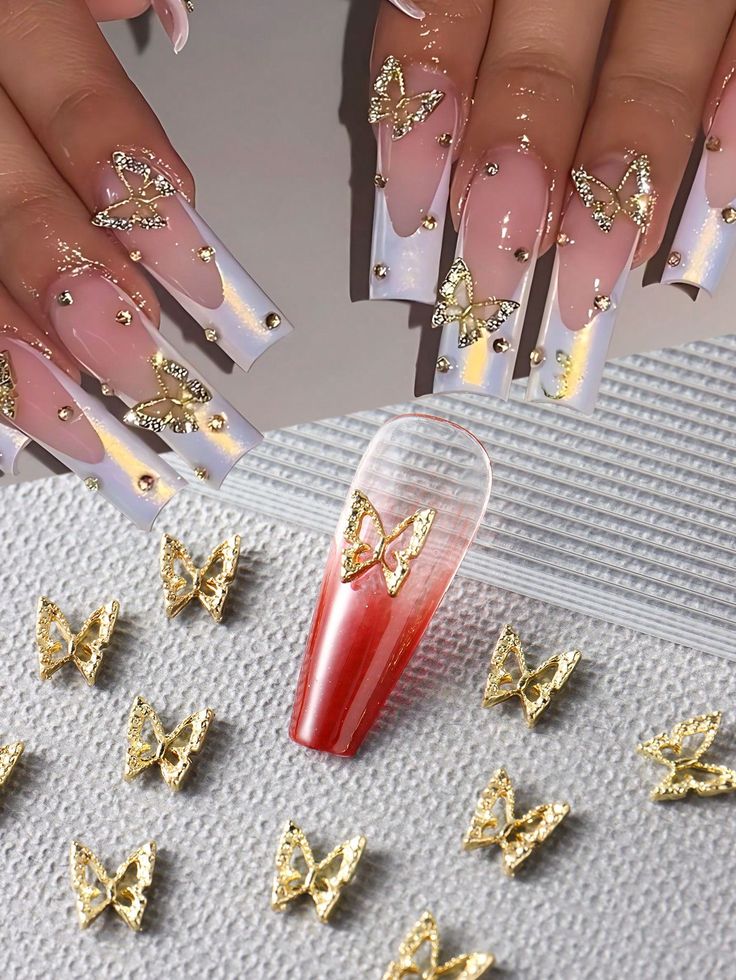 Whimsical Elegant Nail Design with Elongated Acrylics, Butterfly Embellishments, and Gold Accents.