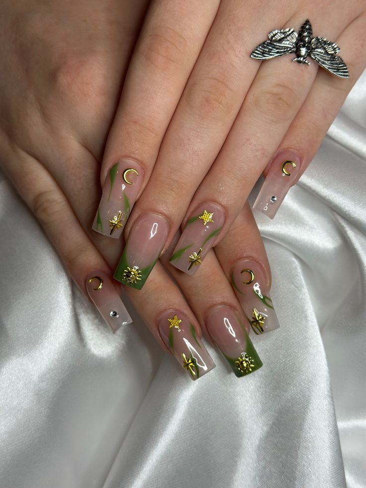 Whimsical Nail Design: Neutral Base with Delicate Green Tips and Intricate Gold Accents.