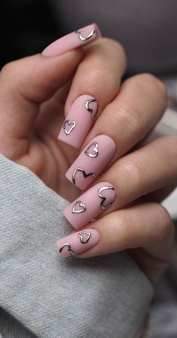 Chic Soft Pink Matte Nails with Delicate Metallic Heart Accents.