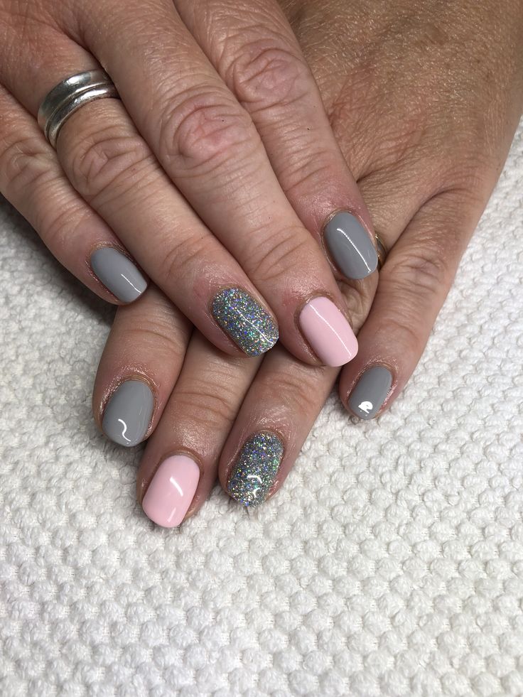 Chic and Elegant Nail Design: Muted Gray and Pastel Pink with Glamorous Glitter Accent.