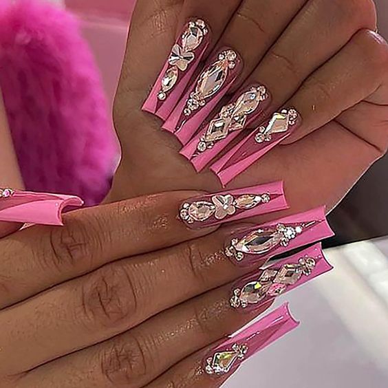 Glamorous Pink Pointed Nail Design Adorned with Sparkling Rhinestones.