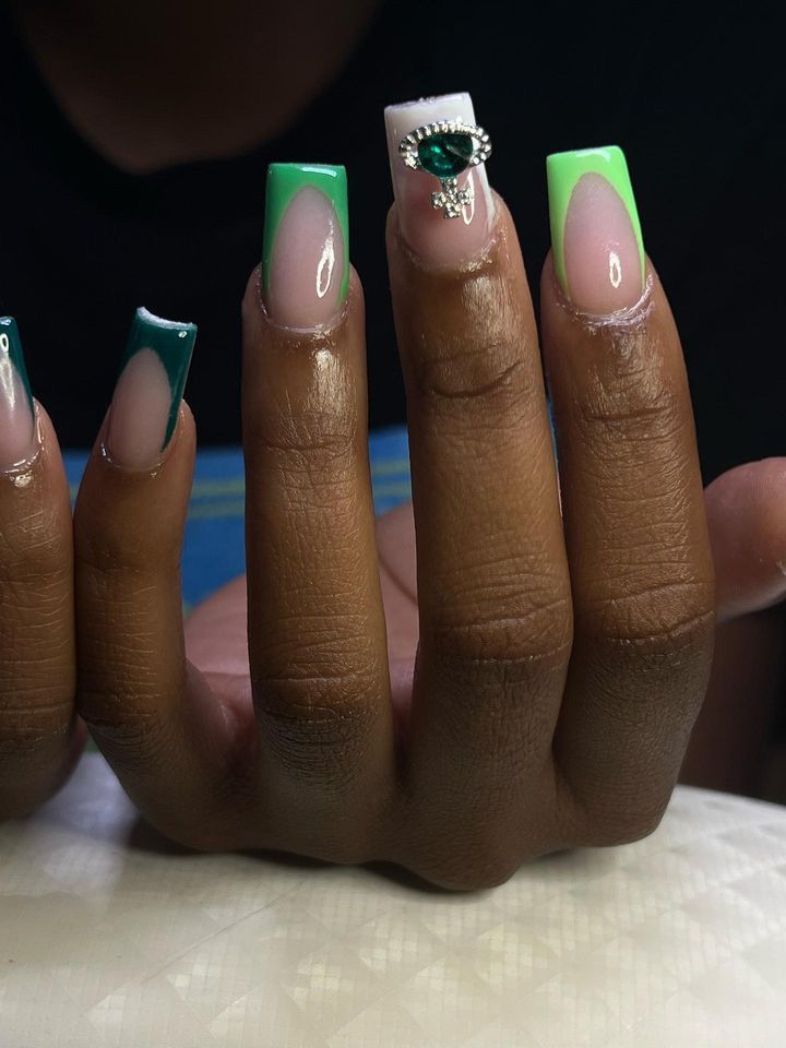 Vibrant Green and Nude Nail Design with Unique Shapes and Gem Accent.