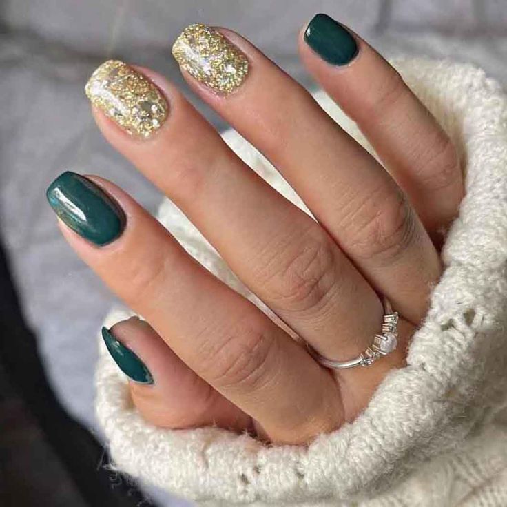 Glamorous Emerald Green Nail Design with Gold Glitter and Rhinestones.