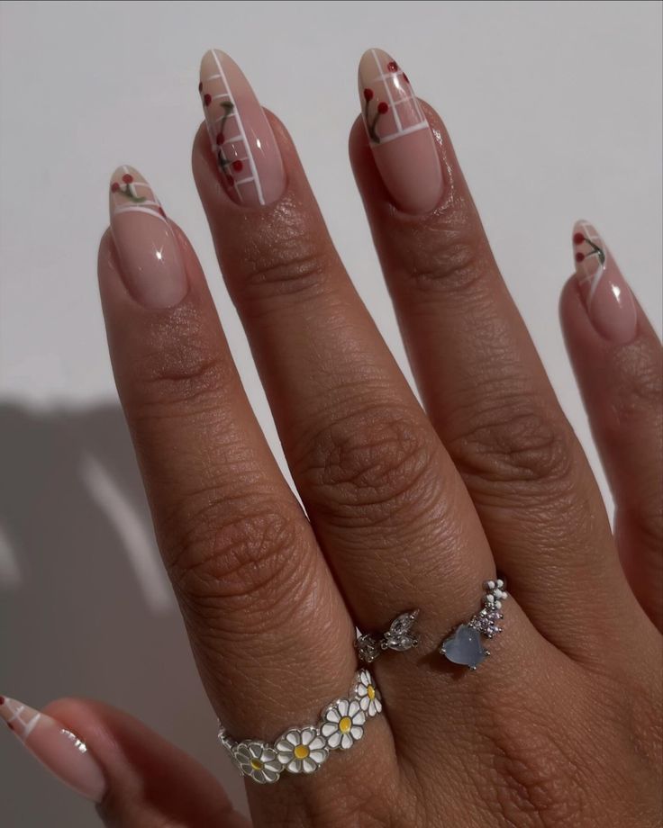 Sophisticated Floral Nail Art with Chic French Tips and Stacked Rings.