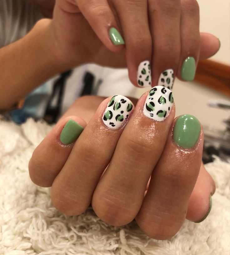 Trendy Playful Nail Design: Vibrant Green Base with Spotted White Accents and Leopard Print.