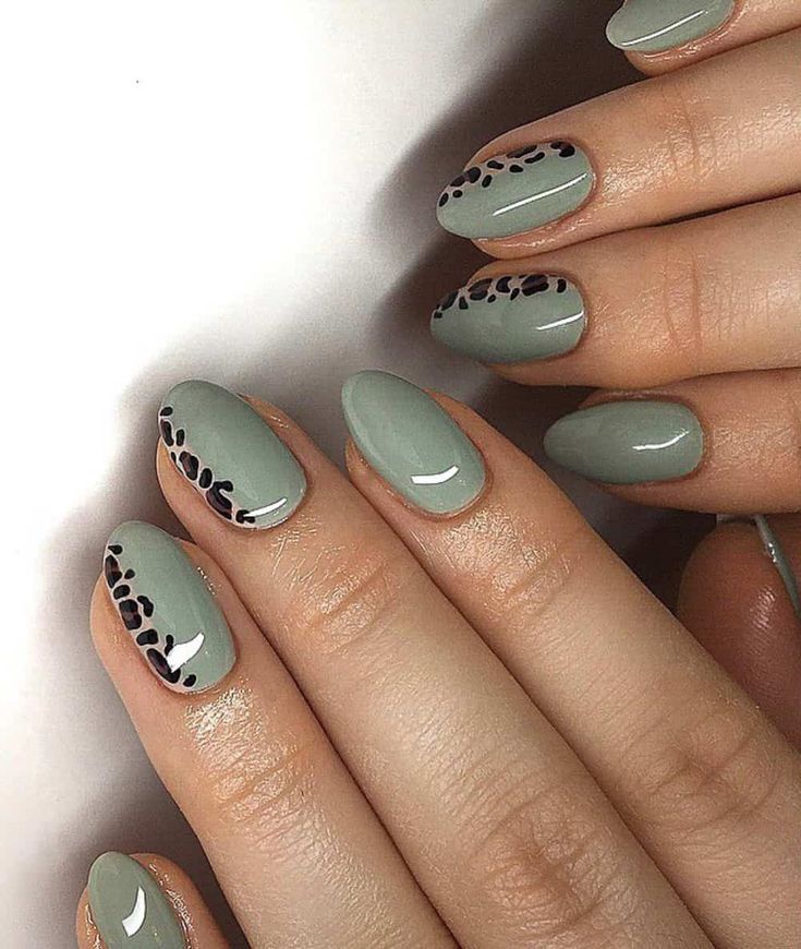 Chic Muted Green Nail Design with Glossy Finish and Playful Black Leopard Print.