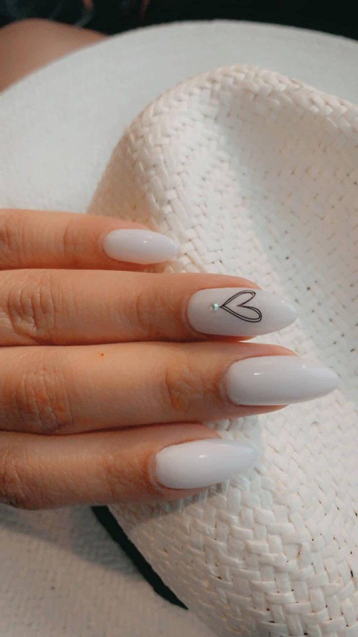 Chic White Pointed Nails with Heart Design and Sparkling Gemstone for Versatile Elegance.