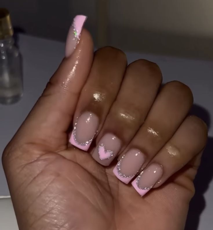 Charming Pink and Sparkling Tip Nails with Subtle Heart Design for any Occasion.