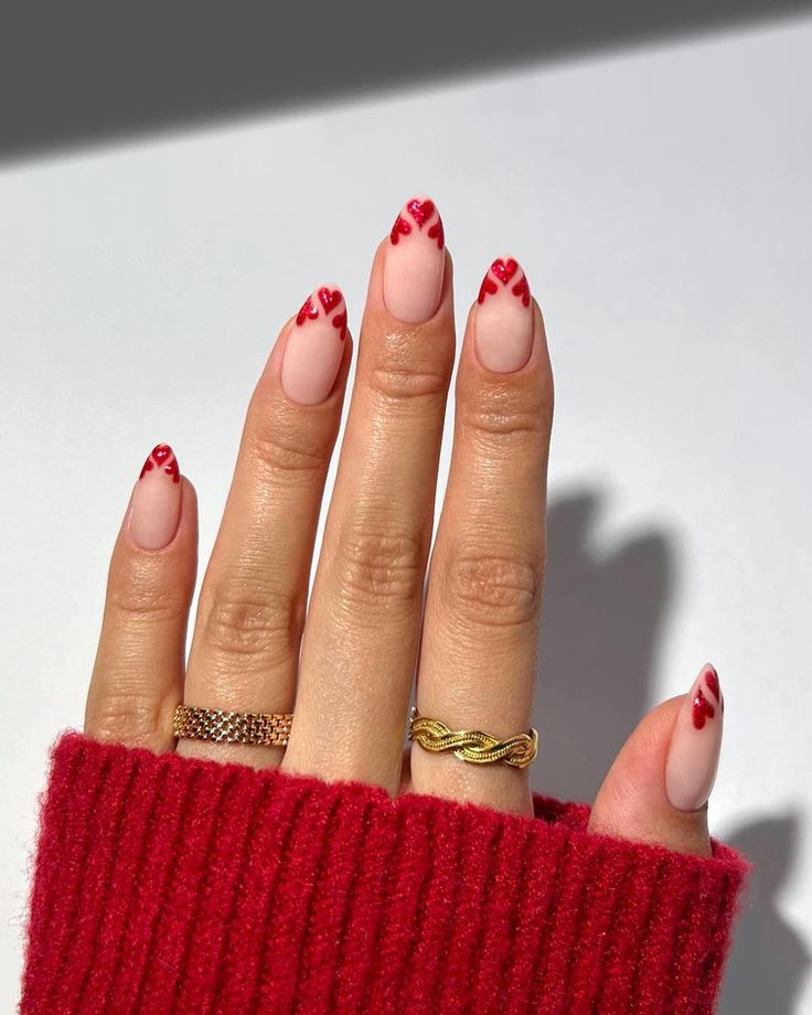 Elegant Chic Nail Design: Nude Base with Artistic Red Heart Accents.