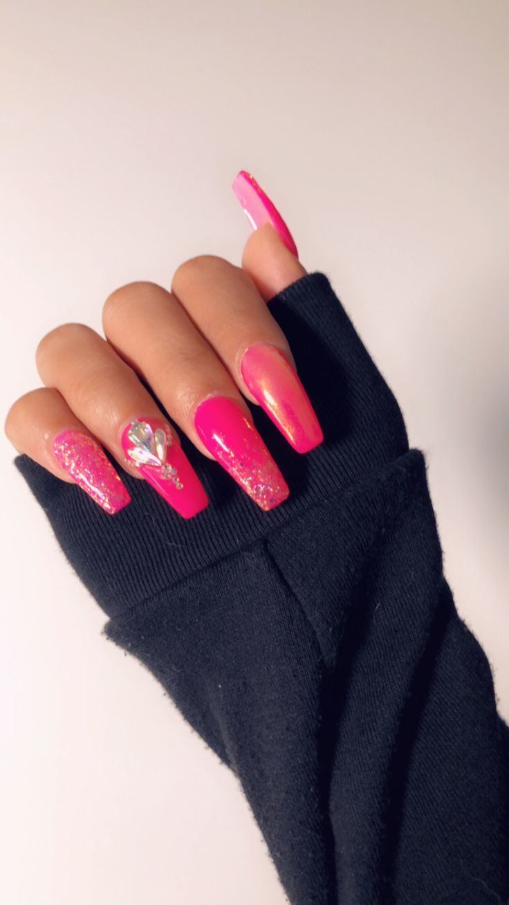 Bold Glam: Eye-Catching Gradient Pink Nails with Glitter and Gem Accents.