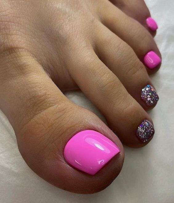 Bold and Cheerful Vibrant Pink Toenails with Sparkly Accents Perfect for Any Occasion.