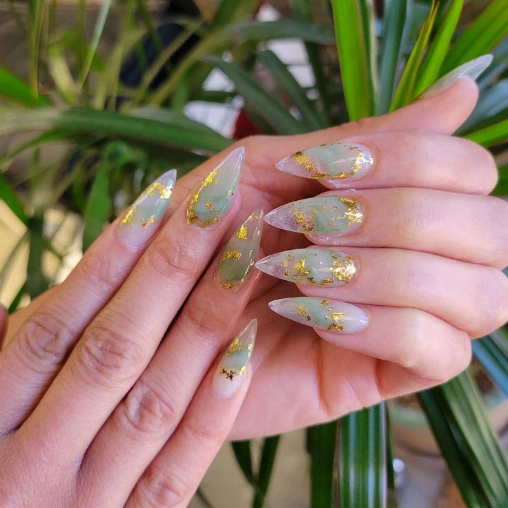 Sophisticated Soft Green Almond Nails with Delicate Gold Flakes for Any Occasion.