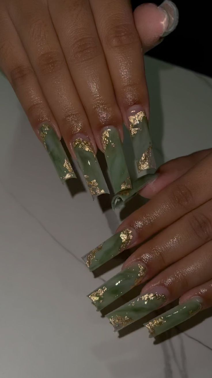 Sophisticated Green Manicure with Glossy Finish and Gold Leaf Accents.