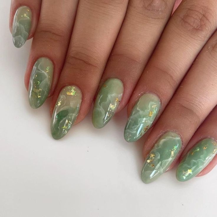 Elegant Textured Green Nail Design with Marbled Effect and Gold Foil Accents.