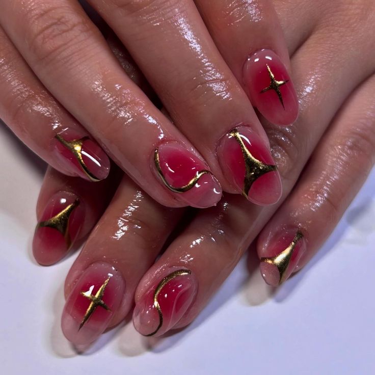 Sophisticated Nail Design: Soft Pink Hues with Striking Gold Accents and Intricate Patterns