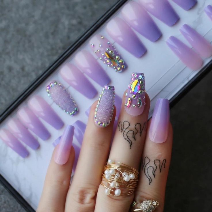 Playful and Elegant Lavender Nail Design with Textures and Sparkling Embellishments.